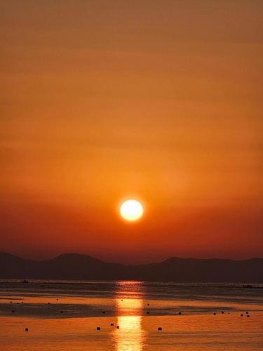 a sunset on the beach with the sun setting at Goseong Essay The in Goseong