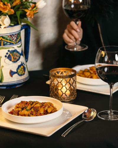 a table with two plates of food and a glass of wine at Blair House Inn and Spa in Wimberley