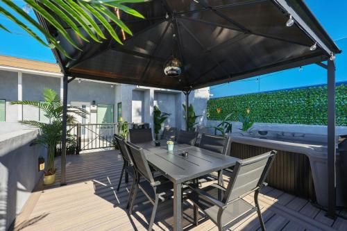 a table and chairs under an umbrella on a deck at Harborside Suite 08 with Hot Tub in San Diego