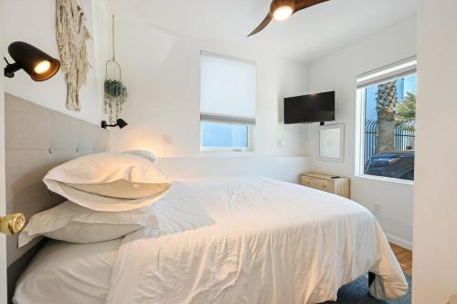 a white bedroom with a bed and a tv at Harborside Suite 08 with Hot Tub in San Diego