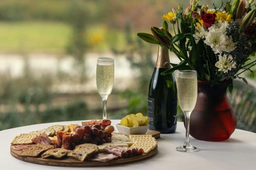 a table with a plate of food and two glasses of champagne at Blair House Inn and Spa in Wimberley