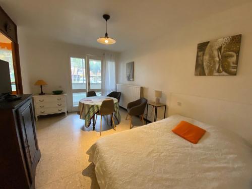 une chambre avec un lit et une table avec des chaises dans l'établissement Studio lumineux avec climatisation, parking et animaux admis à Balaruc - FR-1-503-181, à Balaruc-les-Bains