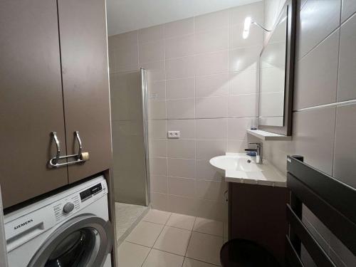 une salle de bain avec une machine à laver et un lavabo dans l'établissement Superbe T3 au Lavandou avec balcon et parking - FR-1-308-205, au Lavandou
