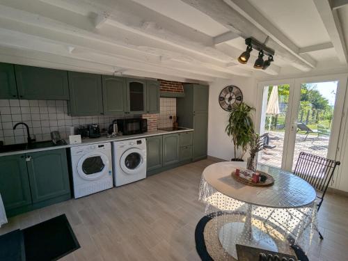 une cuisine avec des armoires vertes et une table avec une table dans l'établissement Maison de charme avec terrasse et jardin clos à Messas - FR-1-590-568, à Messas