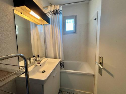 une salle de bain avec un lavabo, une baignoire et un miroir dans l'établissement Appartement 2 pièces, 4 couchages, parking, La Londe-les-Maures - FR-1-826-6, à La Londe-les-Maures