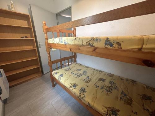 - une chambre avec des lits superposés et un couvre-lit dans l'établissement Appartement 2 pièces, 4 couchages, parking, La Londe-les-Maures - FR-1-826-6, à La Londe-les-Maures