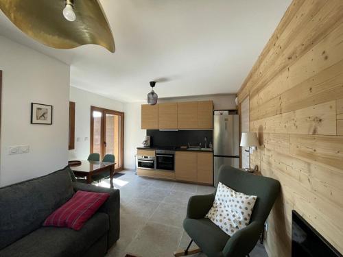 un salon avec un canapé et une cuisine dans l'établissement Appartement moderne 4 pers. avec terrasse sud - FR-1-733-165, à Cohennoz