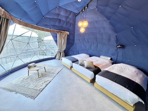 a blue room with a bed and a table at lastpiece in Itoshima