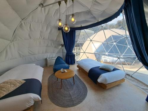 a room with two beds and a table in a tent at lastpiece in Itoshima