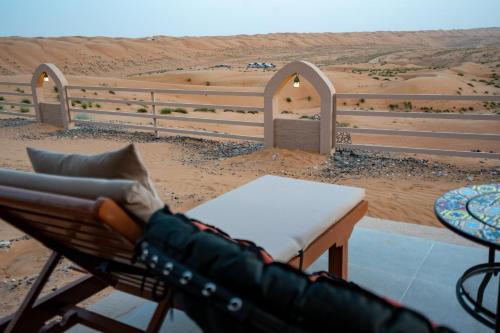 a view of a desert with a table and a chair at Stars Gate Camp in Al Wāşil