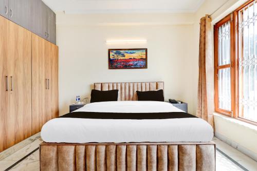 a bedroom with a large bed with a wooden headboard at 3BHK Luxury Apartment- LOTUS INN in Gurgaon