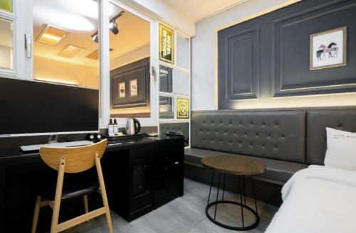 a bedroom with a bed and a desk with a computer at Hotel Yoegieottae Gwangju Hanam in Gwangju