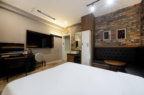 a hotel room with a bed and a tv and a bedroom at Hotel Yoegieottae Gwangju Hanam in Gwangju