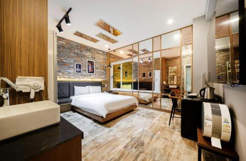 a bedroom with a bed and a desk in it at Hotel Yoegieottae Gwangju Hanam in Gwangju