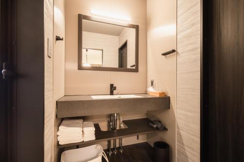 a bathroom with a sink and a mirror at Beppu 乃音 in Beppu