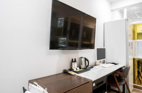 a desk with a computer and a monitor on a wall at Hotel Yoegieottae Gwangju Hanam in Gwangju