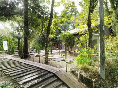 un pont en bois dans un jardin avec des arbres dans l'établissement ALL SEASON RESORT No7 Morinone, à Ichigaya