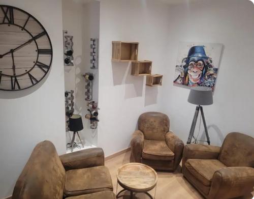 - un salon avec mobilier et grand réveil dans l'établissement Appartement plein centre ville place des vosges, à Épinal