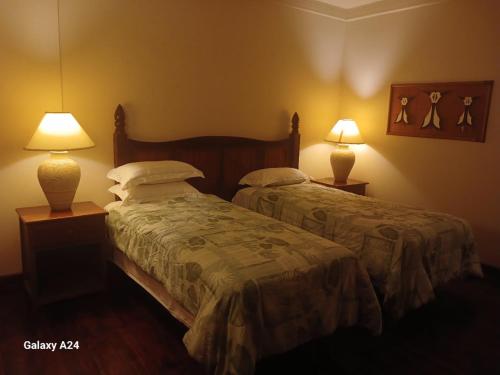 two beds in a hotel room with two lamps at Yap Pacific Dive Resort in Yaptown