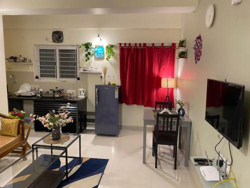 soggiorno con cucina e tenda rossa di Gachibowli ' House of Color's Susi Stays-303 1 BHK a Gachibowli