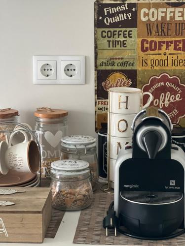a kitchen counter with a coffee maker and jars of food at Modern Twin Room with a balcony in Montijo