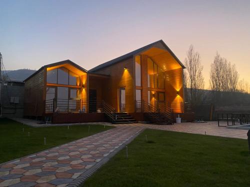 a large wooden house with windows on a lawn at Open House in Orto-Say
