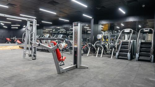 a gym with a lot of machines in it at Brzeen Hotel Riyadh in Riyadh