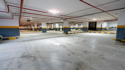 an empty parking garage with white arrows on the floor at Brzeen Hotel Riyadh in Riyadh