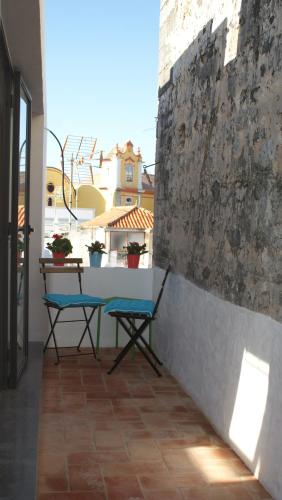 a table and two chairs on a balcony at Casas da Formosa - Casa do Postigo in Tavira