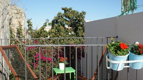 a balcony with flowers and plants in buckets at Casas da Formosa - Casa do Postigo in Tavira