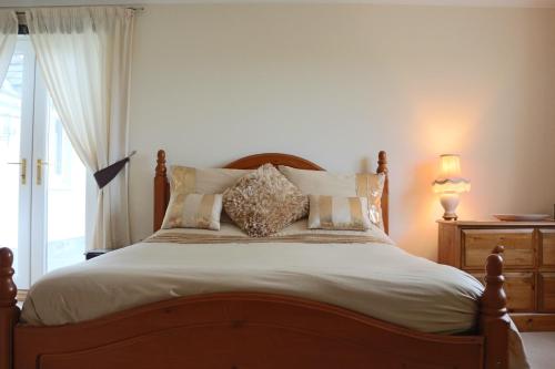 a bedroom with a large bed with white sheets and pillows at Pantysgyfarnog near Carmarthenshire Pembrokeshire in Carmarthen