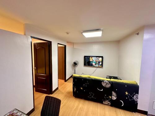 a living room with a couch and a television at Fetalino's Place Imus in Imus