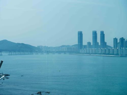 a large body of water with a city in the background at Meomulda Ga Gwangan Poolvilla in Busan