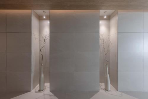 a room with white walls and vases on the floor at Meomulda Ga Gwangan Poolvilla in Busan