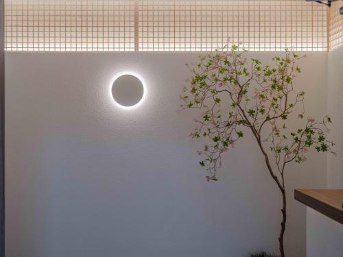 a light on a wall next to a plant at Meomulda Ga Gwangan Poolvilla in Busan