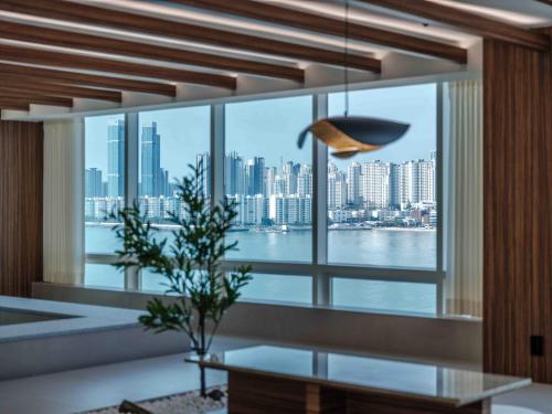 a room with a large window with a view of the city at Meomulda Ga Gwangan Poolvilla in Busan