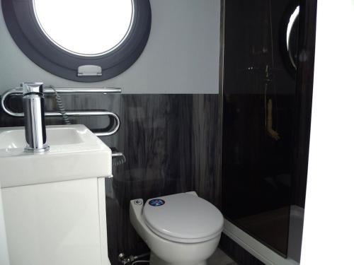 a bathroom with a toilet and a sink and a window at Floating freedom by the Dodekalitten in Torrig