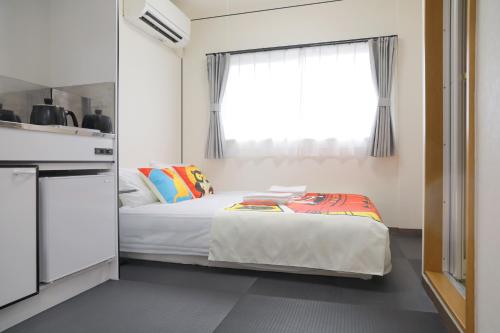 a small bedroom with a bed and a window at oyasumi manga&hotel 难波南店 in Osaka