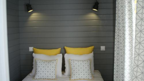 a bedroom with a bed with two pillows and a striped wall at Casas da Formosa - Casa do Postigo in Tavira