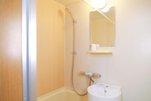a bathroom with a shower and a toilet and a sink at oyasumi manga&hotel 难波南店 in Osaka