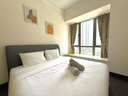 a bedroom with a large white bed with a window at R&F Seine Region in Johor Bahru