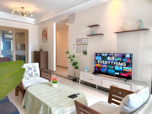 a living room with a television and a table and chairs at R&F Seine Region in Johor Bahru