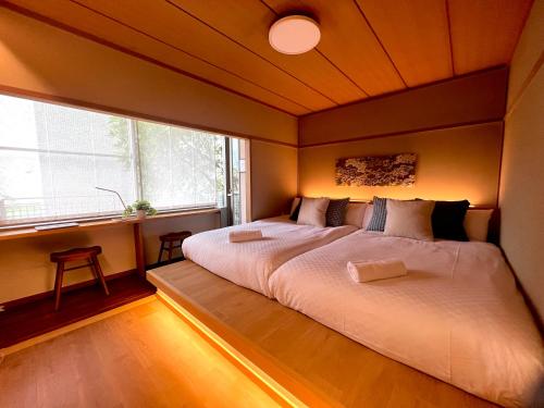 a large bed in a room with a large window at Sakura Residence Hakone in Hakone