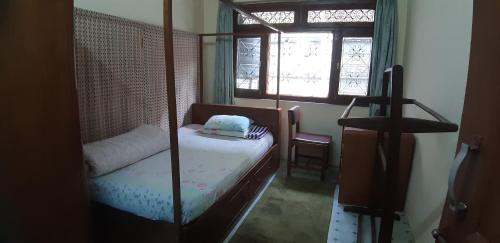 a small bedroom with a bed and a window at Sanu House in Pātan