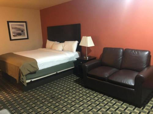 a hotel room with a bed and a couch at Executive inn motel & RV Park in Woodward