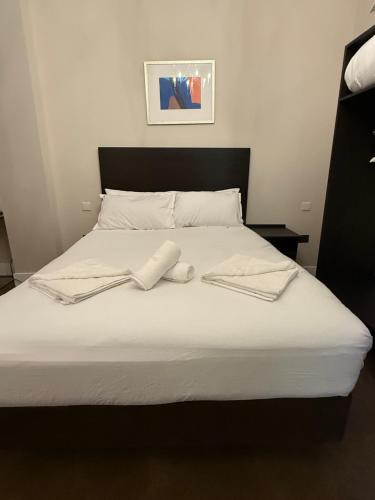 a bed with two white towels on top of it at Green Ariana Hotel - near Wembley and central London in London