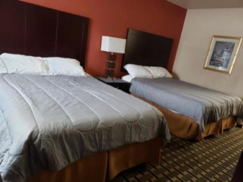 two beds in a hotel room with red walls at Executive inn motel & RV Park in Woodward