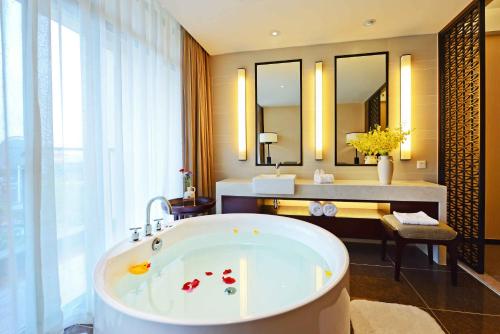 a bathroom with a bath tub and a sink at SSAW Boutique Hotel Hangzhou Qiandao Lake in Chun'an
