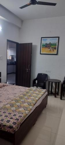 a bedroom with a bed and a table and a painting at Aashiyana Home Stay, Arera Colony, Bhopal in Bhopal