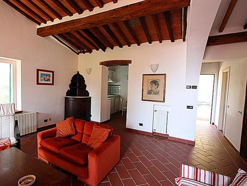 a living room with a red couch and a table at Villa San Giuseppe in Porto Azzurro
